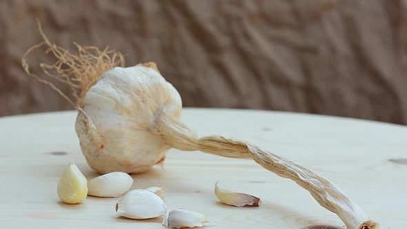 A garlic bulb and grains on a wooden rustic board. Healthy food. dry garlic rotation