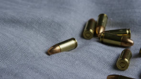 Cinematic rotating shot of bullets on a fabric surface