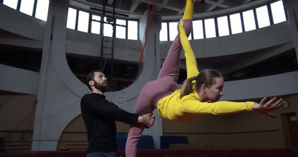 Beautiful Circus Show Training Woman Is Doing a Split While a Man Is Holding