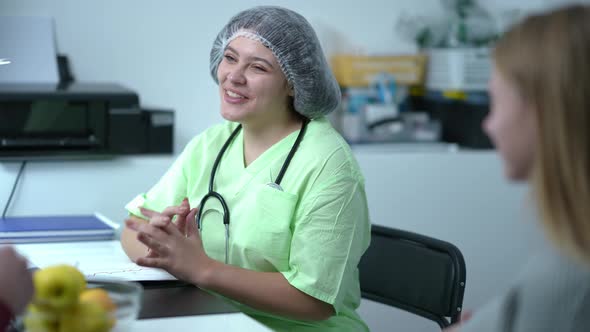 Friendly Smiling Professional Gynecologist Shaking Hands with Unrecognizable Man and Blurred Woman