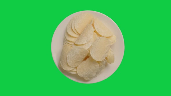 Potato chips in white plate rotation on chroma key green screen background. Alpha Channel. alt