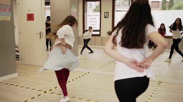 Women and girls dancing hip hop with instructor in hall