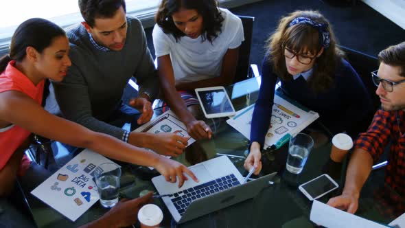 Executives discussing over laptop