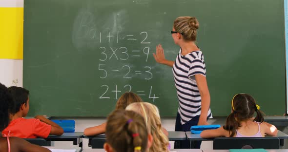 School kids raising hand in classroom