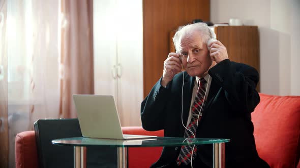 Elderly Grandfather - Aged Grandfather Adjusting His Headphones and Continues To Dance While Sitting