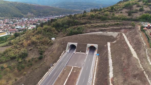 Highway entering a tunnel, Town behind. Road exiting the tunnel.