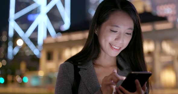 Businesswoman use of smart phone in city at night