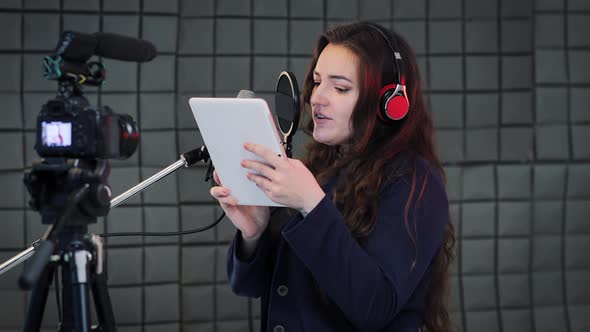 A female voice actor recording animated voices into a professional microphone