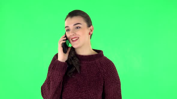 Portrait of Smiling Girl Talking for Mobile Phone and Rejoice. Green Screen