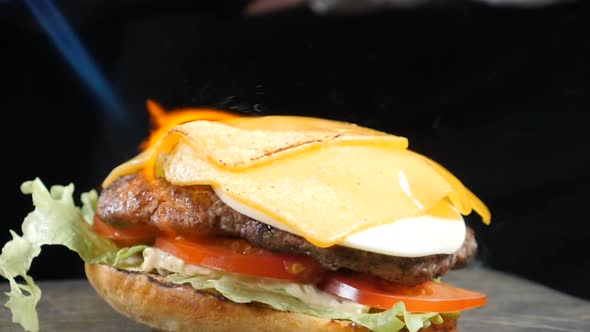 Cook Using Blow Torch To Melt Cheese on Meat Cutlet of Burger. Slow Motion Food Video. Burger