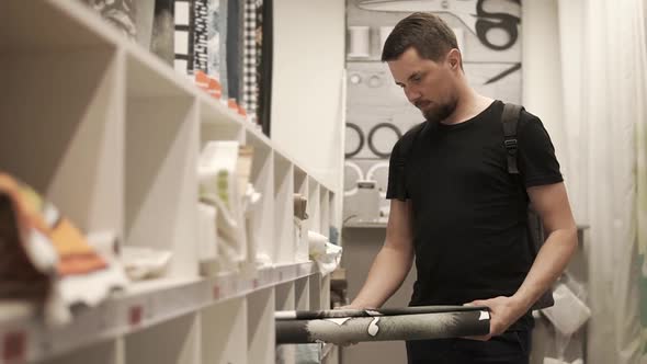 Man Chooses a Carpet for Stylish Apartment the Gentleman Looks at the Material