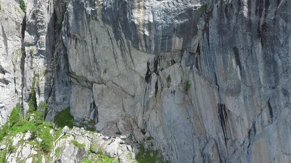 Aerial drone view of a man rock climbing up a mountain
