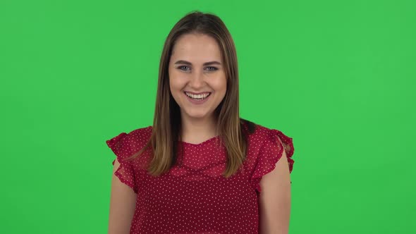 Portrait of Tender Girl in Red Dress Is Laughing. Green Screen