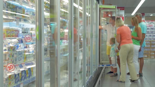 Family By the Refrigerator in the Supermarket