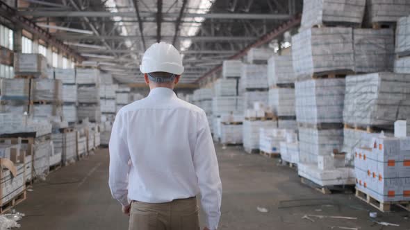 Follow footage of employees male warehouse worker engineer in hard hat working.