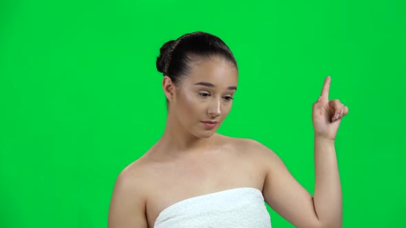 Natural Woman Pointing Finger To Side on Green Screen at Studio. Slow Motion