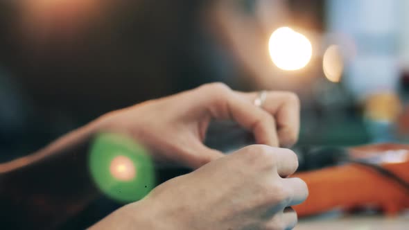 Repair Service Specialist Examining Smartphone Parts