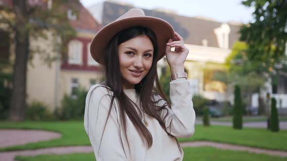 Joyful Lady with Long Brown Hair and Beautiful Hat Which Posing on Camera 