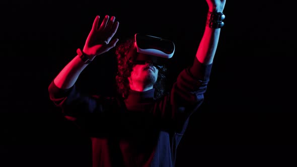 Man with VR Helmet on His Head Playing in Redblue Lights Online Party