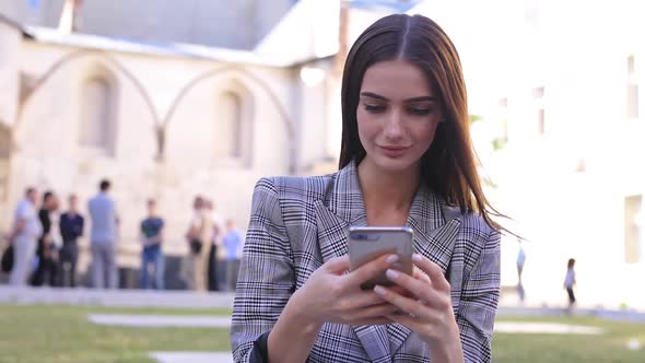 Woman With Phone. Beautiful Girl Using Smartphone Outdoors