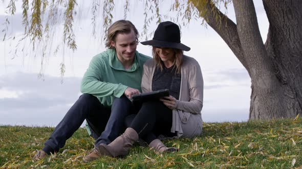 Young man and woman drawing on tablet and laughing