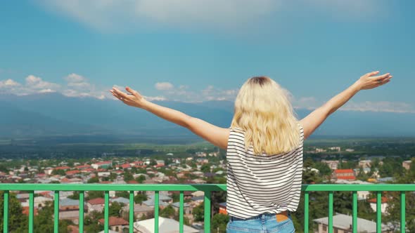 Blond Girl with Outstretched Hands on a Marvelous View of Alazani Valley and Caucasus Mountains in