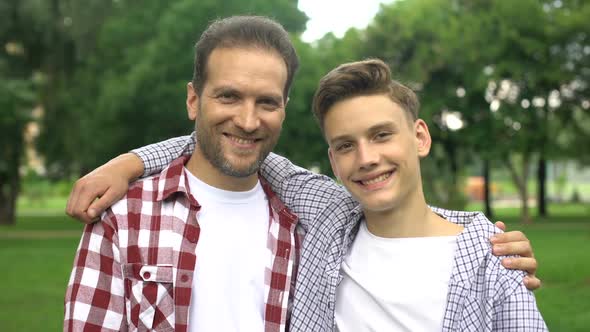 Happy Son and Father Showing Thumbs-Up, Enjoying Pastime Together, Picnic