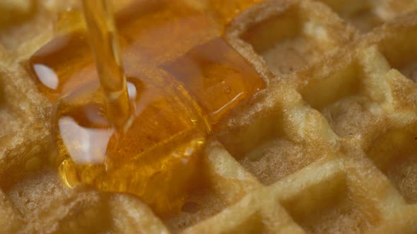 Pouring Maple Syrup on Delicious Belgian Golden Waffles