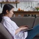 Asian Woman Resting on Couch Using Laptop Notebook Looking at Screen Typing Message at Living Room - VideoHive Item for Sale