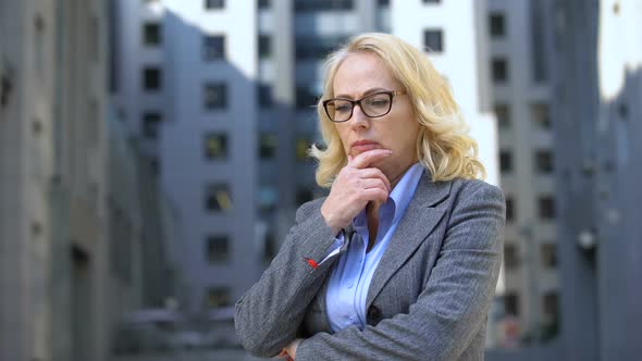 Pensive Female Director in Eyeglasses Standing Outdoors, Work Stress, Anxiety