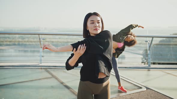 Sporty Diverse Ladies Warming Up Before Sports Workout Outdoors Standing on Bridge in Morning