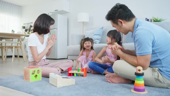 Asian young kid daughter coloring and painting on paper with parents.