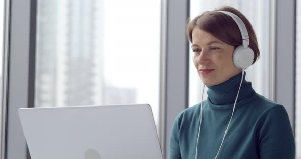 Business woman happily talking on a video call online using a laptop. 