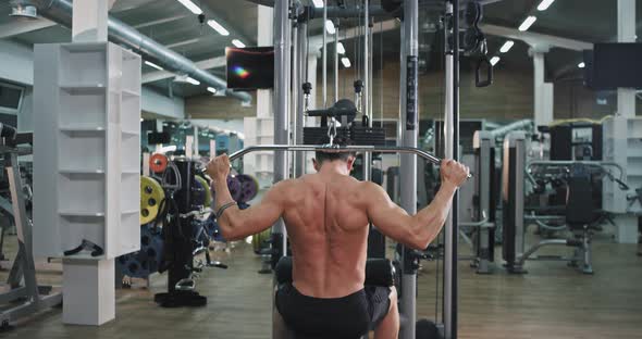 Hard Working Guy at Gym Doing Exercises on His