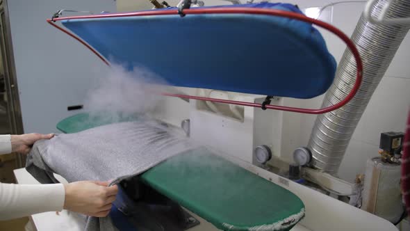 Worker's Hands Holding Blouse During Steaming