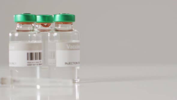 Video of close up of vaccine vials on white background