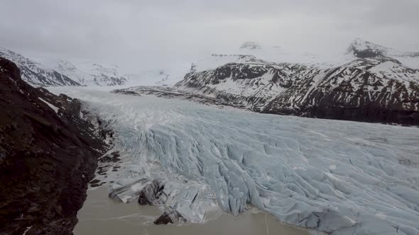 Aerial view of glacier and lake with iceberg floating on the water