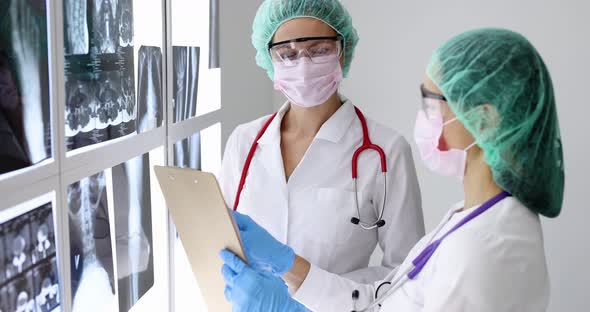 Female Doctor in Protective Masks and Glasses Looking at Medical Documents and Xrays  Movie