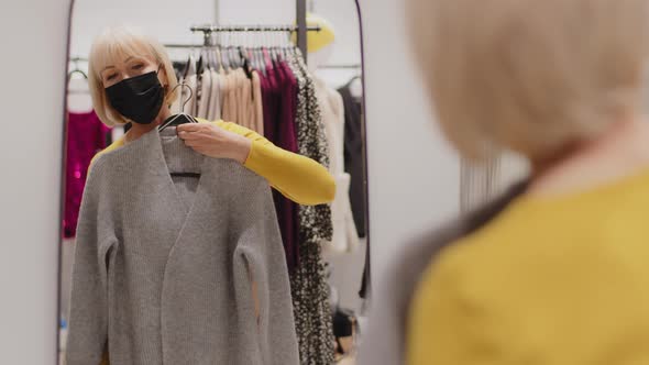 Caucasian Middle Aged Woman Client Customer in Protective Mask in Boutique Clothing Store Stands in