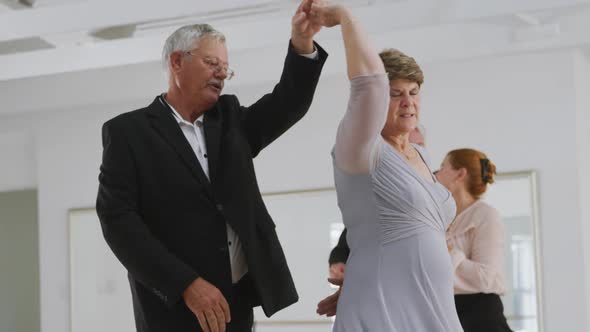 Caucasian senior couples spending time together dancing in a ballroom