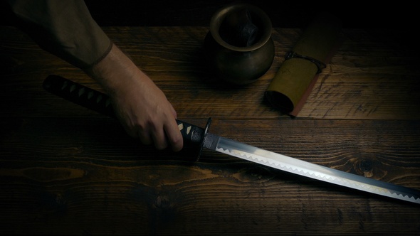 Samurai Sword Is Picked Up From Table alt