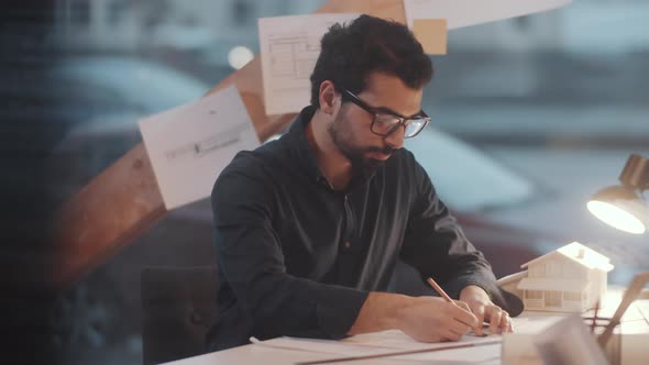Middle Eastern Male Architect Drawing Floor Plan on Paper at Desk