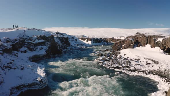 Aerial View of Godafoss Waterfall with Snowy Shore and Ice. Iceland. Winter 2019