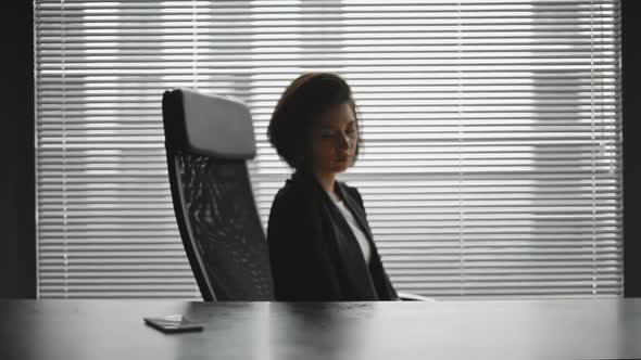Silhouette of Tired Business Lady in Ofiice Behind the Desk