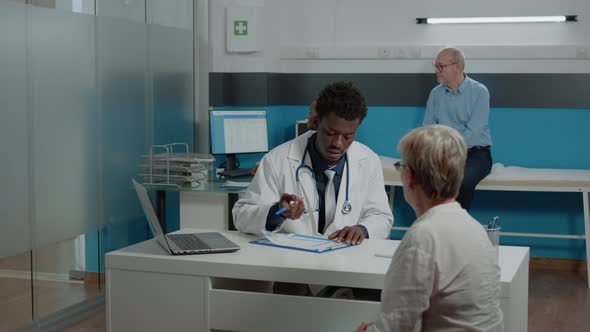 African American Doctor Consulting Sick Old Woman