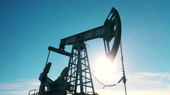 Lowangle Closeup of Oil Pump Jack Moving Against Blue Sky