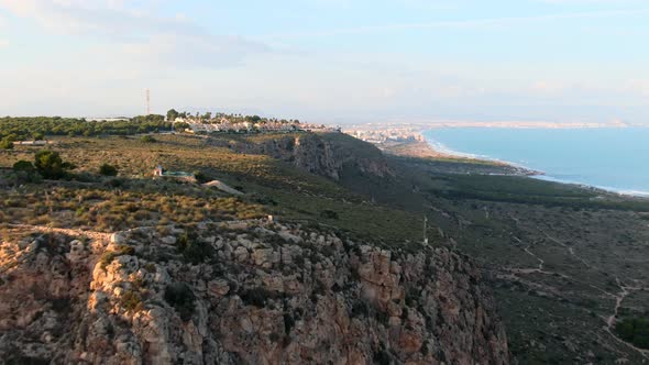 Rocky Green Atlantic Beach Cliff Near Santa Pola, Spain During Sunset.