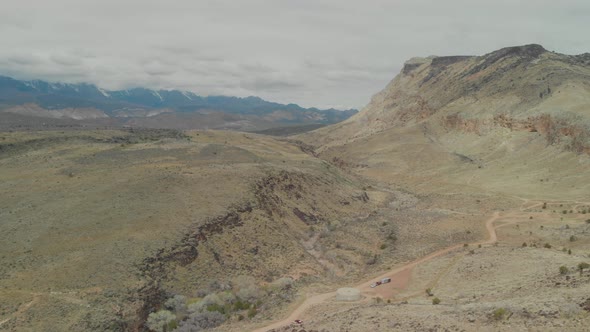 Expansive aerial pan-up of a long dirt road out to southern Utah's Toquerville Falls.