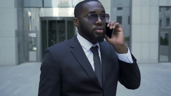 Man in Suit Walking Away from Entrance, Having Conversation on Phone, Careerist