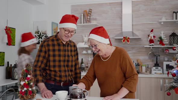 Happy Family with Santa Hat Greeting Remote Friends During Online Videocall Meeting Using Phone